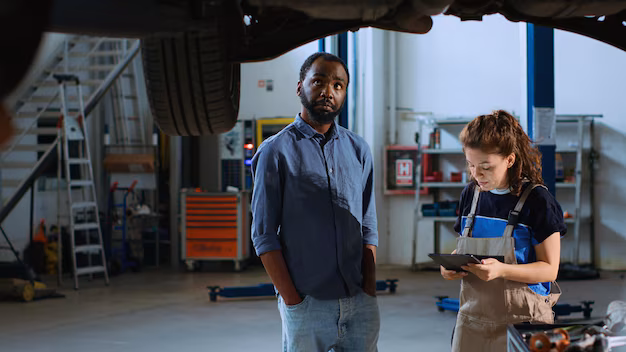 meticulous-technician-garage-workplace-stands-with-customer-underneath-suspended-car